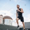 stock-photo-low-angle-view-of-handsome-sportsman-running-and-listening-music-with-smartphone-on-roof-1141839632.jpg
